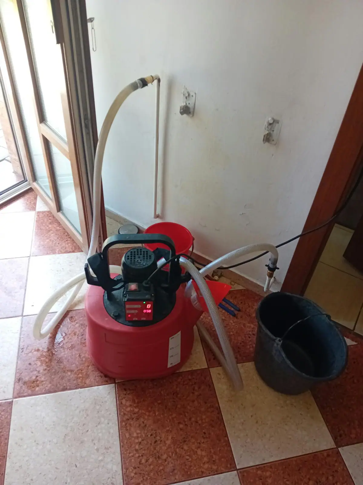 Pompă de spălare racordată la un calorifer, pentru curățarea chimică a instalației de încălzire din Brașov